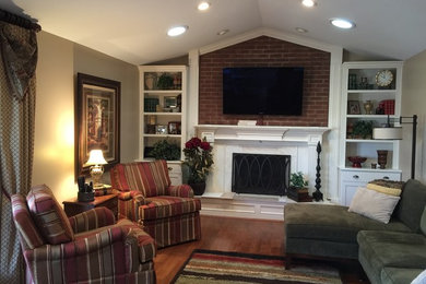 Mid-sized transitional open concept dark wood floor family room photo in Cincinnati with beige walls, a standard fireplace, a wood fireplace surround and a wall-mounted tv