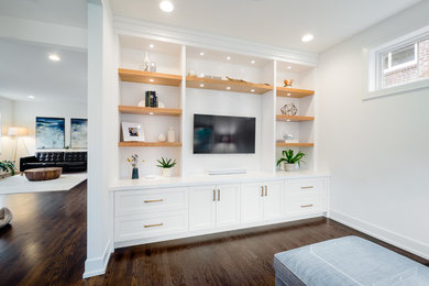 Ejemplo de sala de estar clásica renovada sin chimenea con paredes blancas, suelo de madera oscura, pared multimedia y suelo marrón