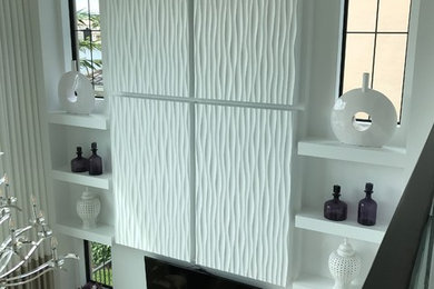 На фото: большая открытая гостиная комната в современном стиле с белыми стенами, полом из керамогранита, телевизором на стене и бежевым полом с