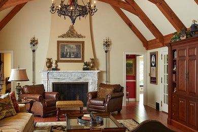 Imagen de sala de estar abierta clásica grande sin televisor con paredes beige, suelo de madera en tonos medios, todas las chimeneas, marco de chimenea de piedra y suelo marrón