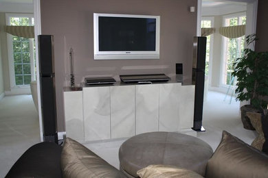 Inredning av ett modernt stort allrum med öppen planlösning, med grå väggar, heltäckningsmatta och en väggmonterad TV
