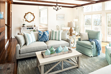 Imagen de sala de estar costera con paredes blancas, suelo de madera en tonos medios y suelo marrón