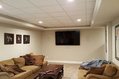 Diseño de sala de estar cerrada tradicional de tamaño medio sin chimenea con paredes beige, moqueta y televisor colgado en la pared