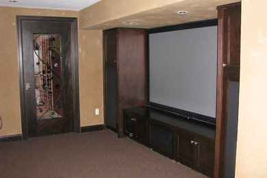 Example of a carpeted family room design in Seattle with a bar, beige walls and a media wall