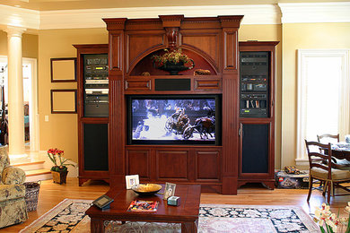 Ejemplo de sala de estar abierta con paredes beige, suelo de madera en tonos medios y pared multimedia