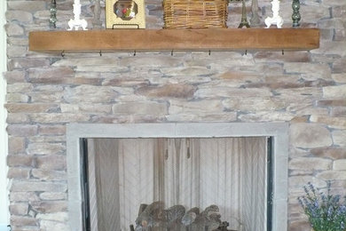 ニューオリンズにあるおしゃれなファミリールーム (標準型暖炉、石材の暖炉まわり) の写真