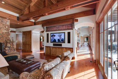 Example of a large southwest open concept medium tone wood floor and brown floor game room design in Philadelphia with white walls, no fireplace and a wall-mounted tv
