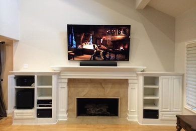 Ejemplo de sala de estar tradicional de tamaño medio con paredes beige y televisor retractable