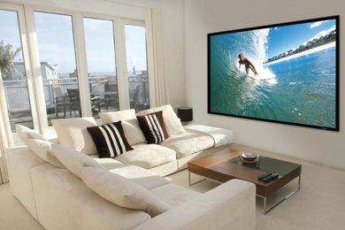 Modelo de sala de estar cerrada de tamaño medio sin chimenea con paredes beige, moqueta, televisor colgado en la pared y suelo beige