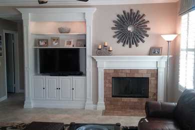 Example of a mid-sized classic open concept travertine floor and beige floor family room design in San Diego with beige walls, a standard fireplace, a brick fireplace and a media wall