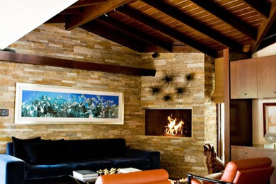 ロサンゼルスにある中くらいなミッドセンチュリースタイルのおしゃれなオープンリビング (無垢フローリング、石材の暖炉まわり、ホームバー、ベージュの壁、横長型暖炉、テレビなし、茶色い床) の写真