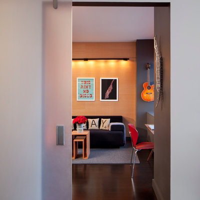 Example of a mid-sized trendy enclosed dark wood floor family room design in New York with multicolored walls, no fireplace and no tv