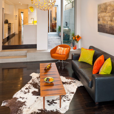 Inspiration for a contemporary dark wood floor and brown floor family room remodel in Sydney with white walls