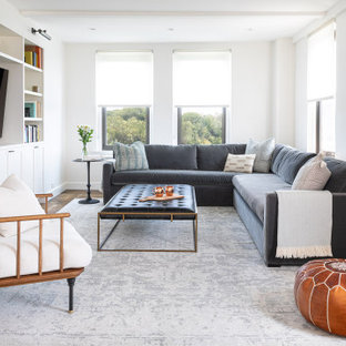 Small transitional enclosed dark wood floor and brown floor family room photo in New York with white walls and a media wall