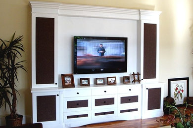 Imagen de sala de estar tradicional con paredes beige, suelo de madera oscura, televisor colgado en la pared y suelo marrón