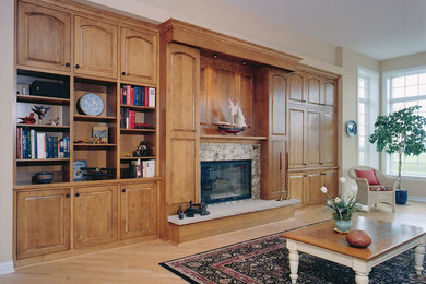 Modelo de sala de estar clásica grande con paredes beige, suelo de madera clara, todas las chimeneas, marco de chimenea de madera y pared multimedia