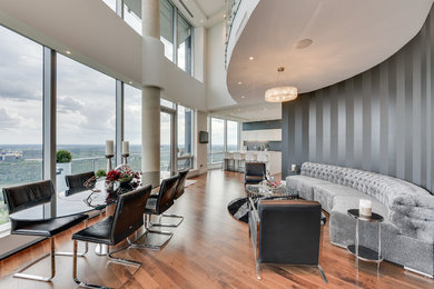 This is an example of an expansive contemporary open plan games room in Calgary with a home bar, grey walls, medium hardwood flooring, no fireplace and no tv.