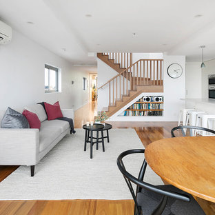 This is an example of a mid-sized modern family room in Melbourne with white walls, medium hardwood floors and brown floor.
