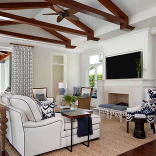 Inspiration for a large tropical open concept brown floor and dark wood floor family room remodel in Miami with white walls, a standard fireplace and a wall-mounted tv