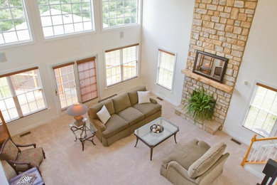Inspiration for a large timeless open concept carpeted and beige floor family room remodel in Columbus with beige walls, a stone fireplace and a standard fireplace