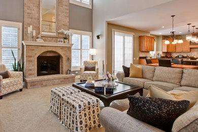 This is an example of a medium sized traditional open plan games room in Chicago with grey walls, carpet, a standard fireplace, a brick fireplace surround and a concealed tv.