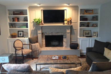 Imagen de sala de estar clásica renovada de tamaño medio con paredes beige, suelo de madera en tonos medios, todas las chimeneas, marco de chimenea de madera y televisor colgado en la pared