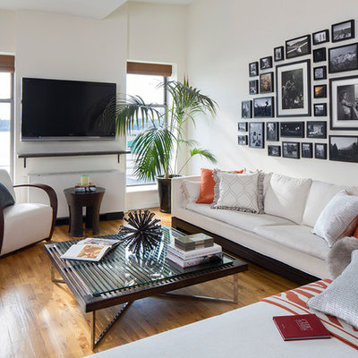 Family room - contemporary open concept medium tone wood floor family room idea in New York with white walls and a wall-mounted tv