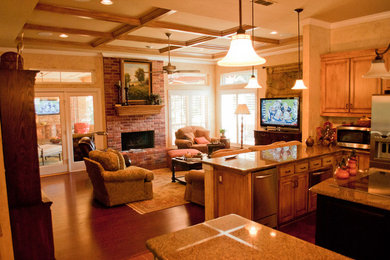 Foto de sala de estar abierta tradicional con suelo de madera oscura, todas las chimeneas y marco de chimenea de ladrillo