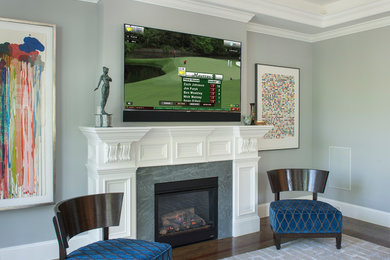 Inspiration for a medium sized contemporary open plan games room in Boston with grey walls, dark hardwood flooring, a standard fireplace, a tiled fireplace surround, a wall mounted tv and brown floors.