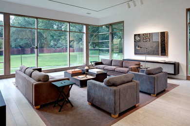 Imagen de sala de estar cerrada minimalista de tamaño medio sin chimenea y televisor con paredes blancas y suelo de madera clara
