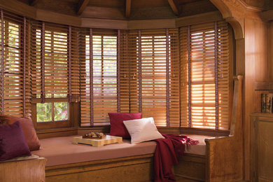 Modelo de sala de estar cerrada tradicional grande sin chimenea con paredes marrones y suelo de madera en tonos medios