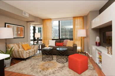 Foto di un soggiorno minimalista di medie dimensioni e chiuso con pareti beige, pavimento in legno massello medio, nessun camino, TV a parete e pavimento marrone