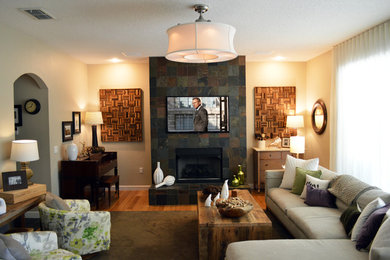 Foto de sala de estar cerrada de estilo americano de tamaño medio con todas las chimeneas, paredes beige, suelo de madera en tonos medios, marco de chimenea de piedra y televisor colgado en la pared