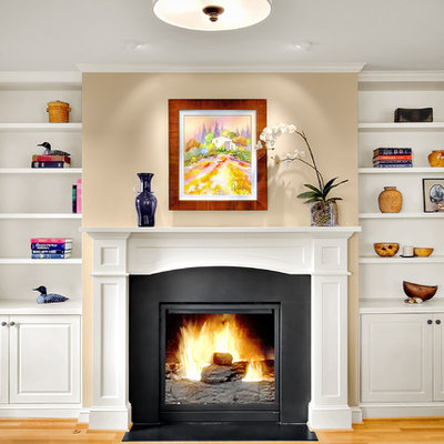 Inspiration for a timeless light wood floor family room remodel in Seattle with beige walls, a standard fireplace and no tv