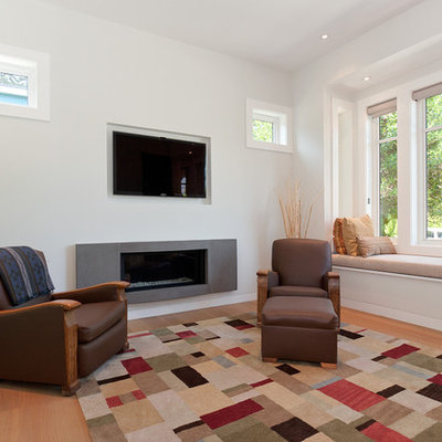 Inspiration for a contemporary enclosed medium tone wood floor family room remodel in Vancouver with white walls, a ribbon fireplace and a wall-mounted tv