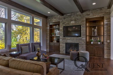 Imagen de sala de estar tradicional renovada con suelo de madera en tonos medios, todas las chimeneas, marco de chimenea de piedra y pared multimedia