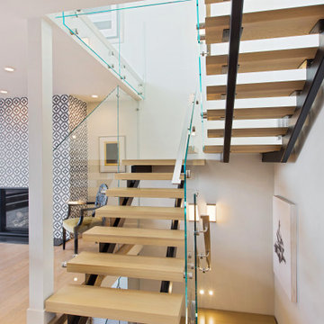 Custom floating stair with glass railings we designed