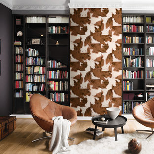 Foto de sala de estar con biblioteca tradicional renovada con paredes negras y suelo de madera clara