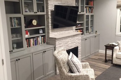 Inspiration for a transitional family room remodel in Indianapolis with gray walls, a stone fireplace and a wall-mounted tv
