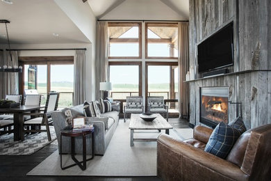 Inspiration for a large rustic open concept dark wood floor and black floor family room remodel in New York with white walls, a standard fireplace, a wood fireplace surround and a wall-mounted tv