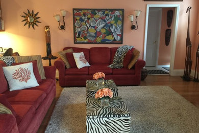 Diseño de sala de estar abierta clásica renovada grande sin chimenea con parades naranjas, suelo de madera clara y pared multimedia