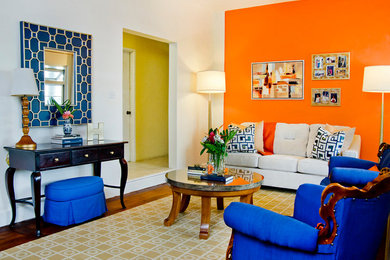 他の地域にある低価格の中くらいなトラディショナルスタイルのおしゃれなオープンリビング (オレンジの壁、塗装フローリング、暖炉なし、テレビなし、茶色い床) の写真