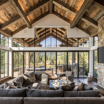 Mountain style dark wood floor family room photo in Jackson with a standard fireplace, a metal fireplace and a wall-mounted tv
