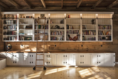 Diseño de sala de estar con biblioteca de estilo de casa de campo con suelo de madera en tonos medios