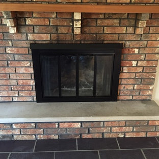 75+ Wohnen mit Kaminumrandung aus Backstein und schwarzem Boden Ideen