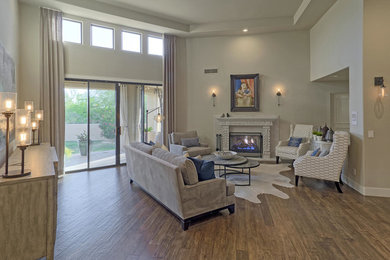 Large transitional open concept dark wood floor family room photo in Phoenix with beige walls, a standard fireplace, a stone fireplace and no tv