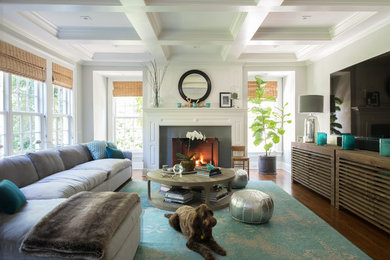 Imagen de sala de estar abierta clásica renovada grande con paredes grises, suelo de madera en tonos medios, todas las chimeneas, marco de chimenea de piedra y suelo marrón