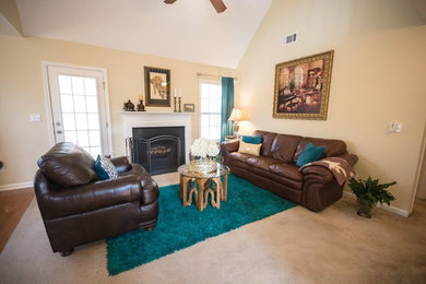 Ejemplo de sala de estar abierta tradicional renovada de tamaño medio sin televisor con paredes beige, suelo de madera clara, todas las chimeneas y marco de chimenea de hormigón