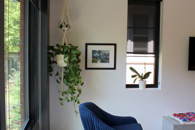 Foto di un piccolo soggiorno minimal aperto con pareti bianche, parquet chiaro, camino classico e cornice del camino in cemento