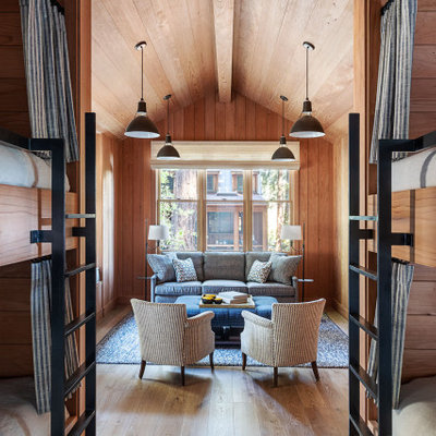 Inspiration for a mid-sized rustic enclosed medium tone wood floor and beige floor family room remodel in San Francisco with beige walls and no fireplace